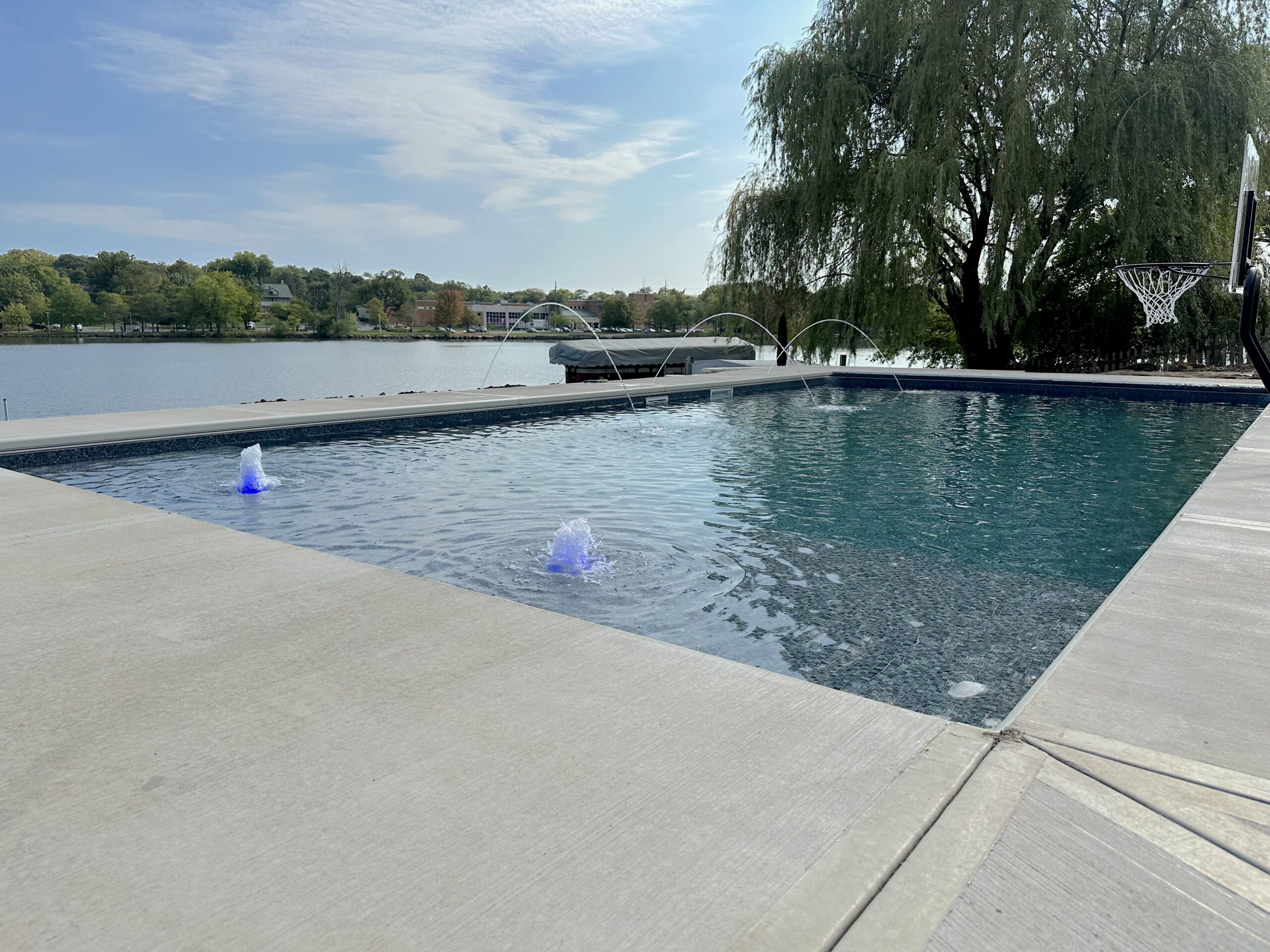 Freeform pool with a spa and a wide stone patio